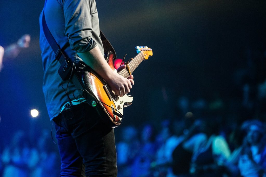 A person playing the guitar at a concert.