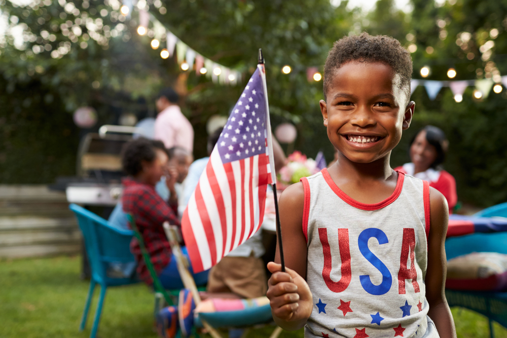 child in USA shirt waving an American flag